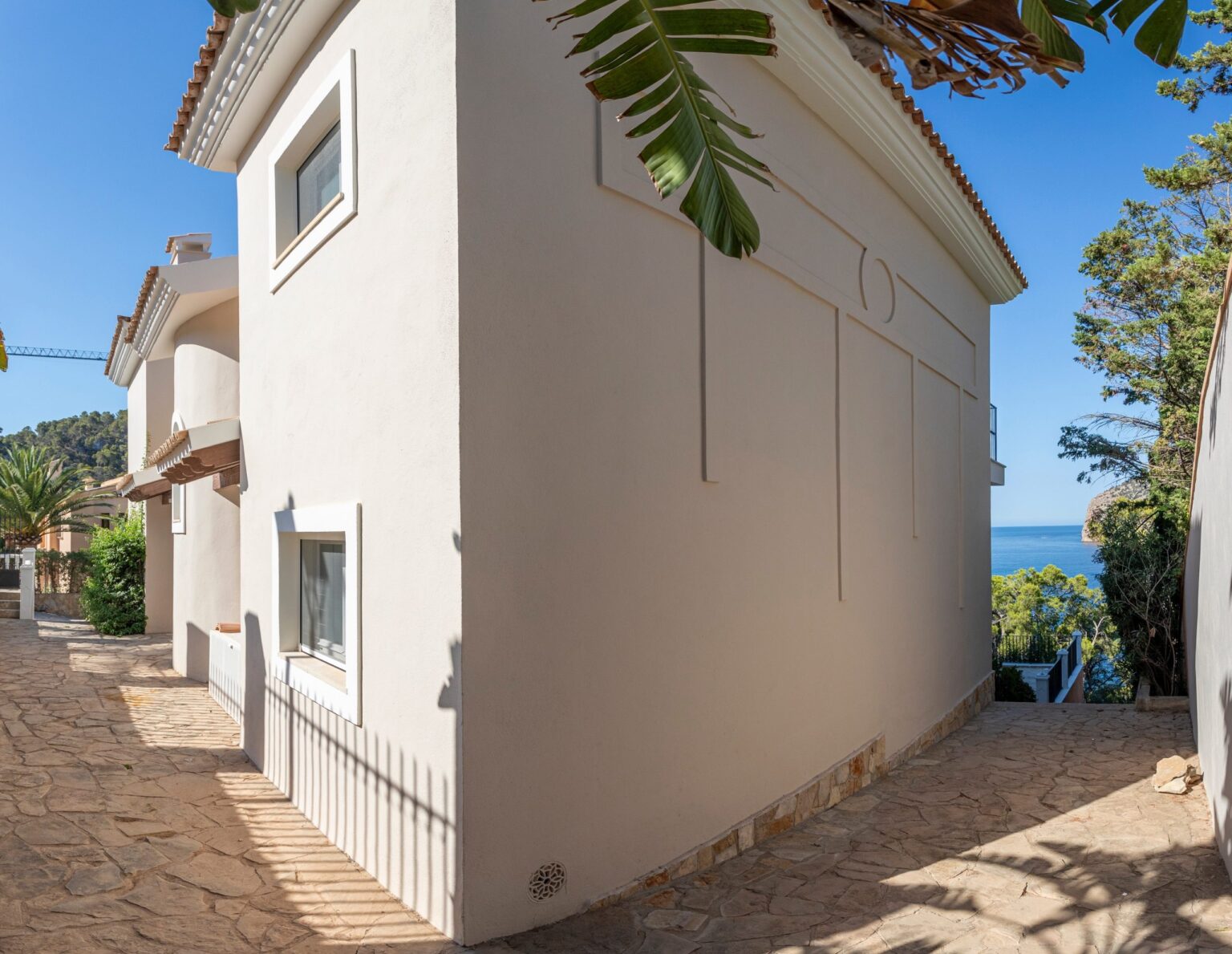 Cocina lineal de diseño con isla central y encimera de silestone tras reformas parciales en Mallorca.